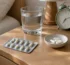 Probiotique et antibiotique : gélules sur une table de chevet avec un verre d'eau et un réveil